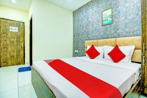 ein Schlafzimmer mit einem großen Bett mit roten Kissen in der Unterkunft OYO Hotel Grace Villa in Ludhiana