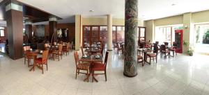un restaurante con mesas y sillas de madera en Bagu Pinamar Hotel en Pinamar