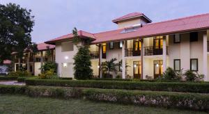 a large white building with a red roof at Hotel Chenra in Kataragama