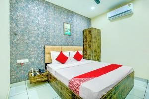 1 dormitorio con 1 cama grande con almohadas rojas en OYO Hotel Grace Villa en Ludhiana