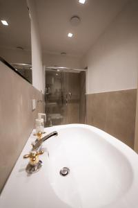 y baño con lavabo blanco y ducha. en Raphael Temporary Home in Urbino en Urbino