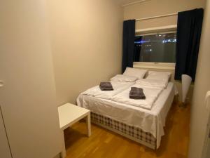 a small bedroom with a bed and a window at Strandkanten Panorama in Tromsø