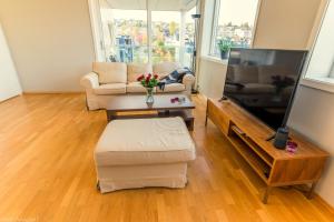 a living room with a couch and a tv at Strandkanten Panorama in Tromsø