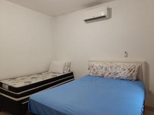 a small bedroom with a bed and a couch at Casa Temporada peterle Iriri in Iriri