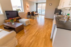 a living room with a kitchen and a living room with a table at Strandkanten Panorama in Tromsø +3 photos
