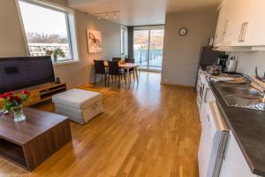 a kitchen and living room with wooden floors and a table at Strandkanten Panorama in Tromsø