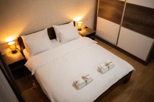 a bedroom with a large white bed with two towels at La Mirage in Šabac