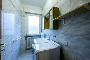 een kleine badkamer met een wastafel en een raam bij Rètro Apartment In The Mountains in Mezzolombardo