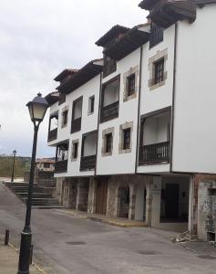 ein weißes Gebäude mit Straßenbeleuchtung davor in der Unterkunft El capricho de Susana in Santillana del Mar