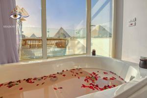 uma banheira cheia de pétalas de flores vermelhas em Shadow Pyramids Suites and Jacuzzi em Cairo