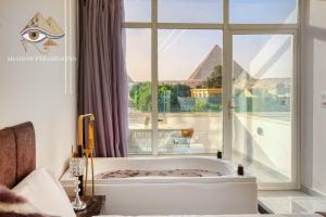 a bath tub in a room with a large window at Shadow Pyramids Palace in Cairo