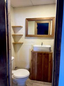 a bathroom with a sink and a toilet and a mirror at Aloha.ayampe in Ayampe