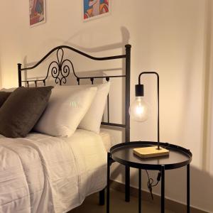 een slaapkamer met een bed en een tafel met een lamp bij GrotteBianche - Sicilian Apartment in Catania