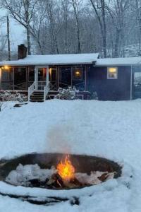a fire pit in the snow in front of a house at Tory Hill in Hillsdale