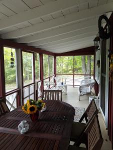 a porch with a wooden table with flowers on it at Tory Hill in Hillsdale