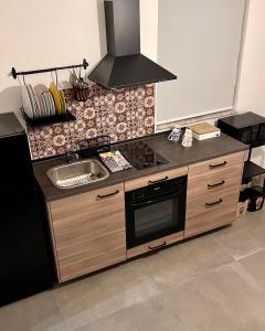 een keuken met een wastafel en een fornuis top oven bij GrotteBianche - Sicilian Apartment in Catania