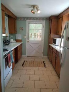 a kitchen with a white door and a tile floor at Tory Hill in Hillsdale