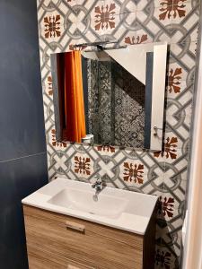 een badkamer met een wastafel en een spiegel bij GrotteBianche - Sicilian Apartment in Catania