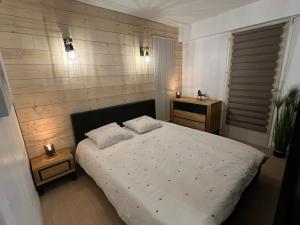 ヴィラール・ド・ランにあるLe Veymont Élégance Montagnardeのベッドルーム1室(白いベッド1台、ナイトスタンド2台付)