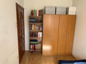 a room with a book shelf with books at Pokój dwuosobowy w Wilanowie in Warsaw