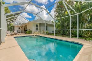 a swimming pool in a house with a glass roof at Private Heated Pool & Beach House in Vero Beach