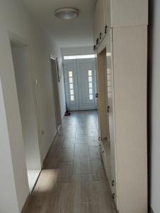 an empty hallway with white doors and a tile floor at Vila Mihajlovic in Brus