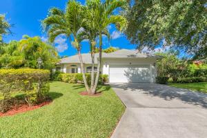 a palm tree in front of a house with a driveway at Private Heated Pool & Beach House in Vero Beach