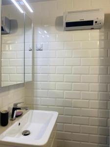 uma casa de banho branca com um lavatório e um espelho em Leunovo Adventure Villa em Leunovo