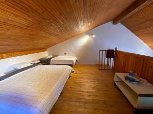 a bedroom with two beds and a wooden ceiling at Leunovo Adventure Villa in Leunovo