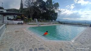 a child in a pool with a frisbee at Finca Maratón Alto in Calarcá