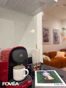 a coffee maker and a cup on a table at Athéna in Caen +1 photo