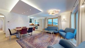 uma sala de estar com cadeiras azuis e uma mesa em Apartments Aeon em Sankt Johann in Tirol