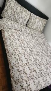 uma cama com um edredão branco e 2 almofadas em Cocooning House em Cugy