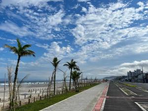 una carretera junto a la playa con palmeras en Lindo apartamento com vista para o mar en Matinhos