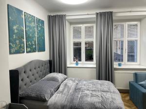 a bedroom with a bed and two windows at Almond Studio Apartment in Bratislava