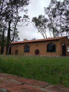 ein Backsteinhaus mit Fenstern auf einem Feld in der Unterkunft Xani Mui in San Jerónimo Aculco