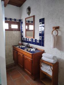 ein Bad mit einem Waschbecken und einem Spiegel in der Unterkunft Xani Mui in San Jerónimo Aculco