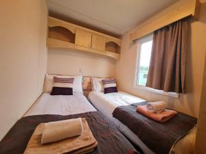 2 łóżka w małym pokoju z oknem w obiekcie BLUE BIRD HOLIDAY HOME w mieście Durham