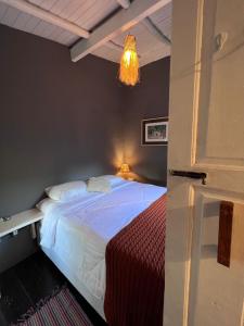 a bedroom with a large white bed with a chandelier at Vila Patí Caraíva in Caraíva