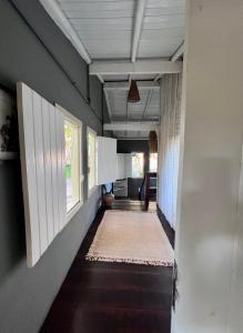 um corredor de uma casa com paredes brancas e um tapete em Vila Patí Caraíva em Caraíva