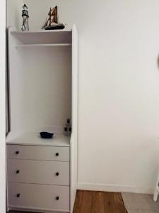 a bedroom with a dresser and a white wall at Studio neuf au calme proche gare maritime - 7 min in Nantes