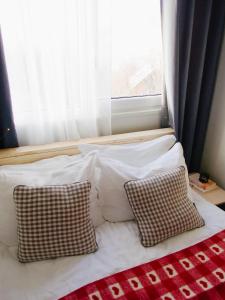 een bed met 2 kussens voor een raam bij Greta Hillside 