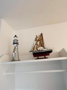 a toy boat and a lighthouse sitting on a shelf at Studio neuf au calme proche gare maritime - 7 min in Nantes