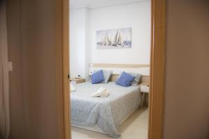 a bedroom with a bed with blue pillows at Beachfront Family Retreat, Marina d'Or in Oropesa del Mar +23 photos