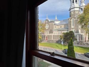 una ventana con vistas a un gran edificio con iglesia en Le 100 St-Laurent, en Louiseville