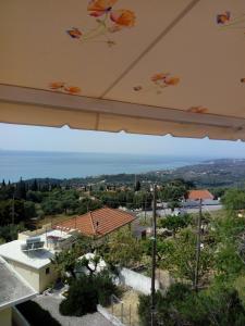 a view from the balcony of a house with an umbrella at Maria's Sea View Apartments in Mousata