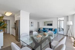 a living room with a glass table and white chairs at Stunning Top floor 2BD 2BA Ocean View Santa Monica in Los Angeles