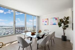a dining room with a table and chairs and large windows at Stunning Top floor 2BD 2BA Ocean View Santa Monica in Los Angeles