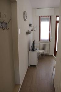 corridoio con camera con scrivania e TV di Casa Smeraldo a San Giovanni Lupatoto