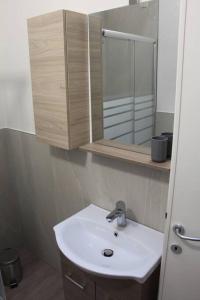 uma casa de banho com um lavatório e um espelho em Casa Smeraldo em San Giovanni Lupatoto